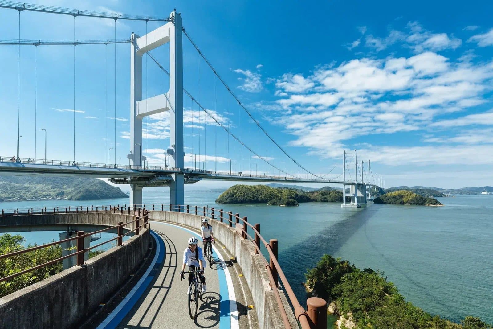 Cyclistes sur la piste d'un pont de la Shimanami Kaido, Japon
